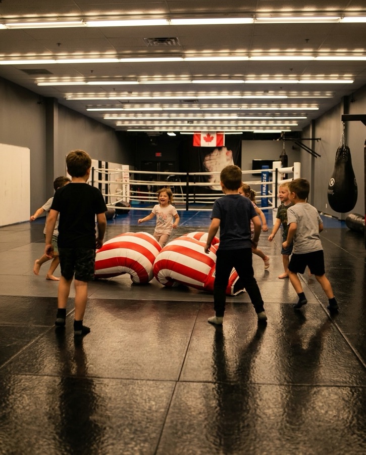 Children playing with oversized jumbo boxing gloves at Rumble Martial Arts.